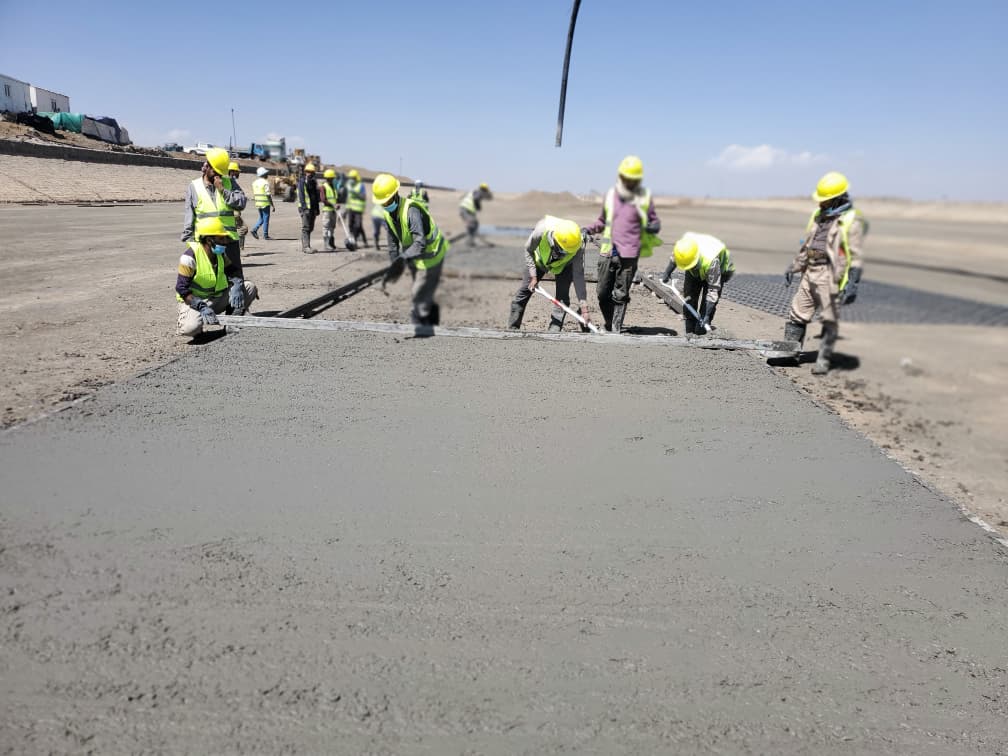 Field team manually levelling fresh concrete