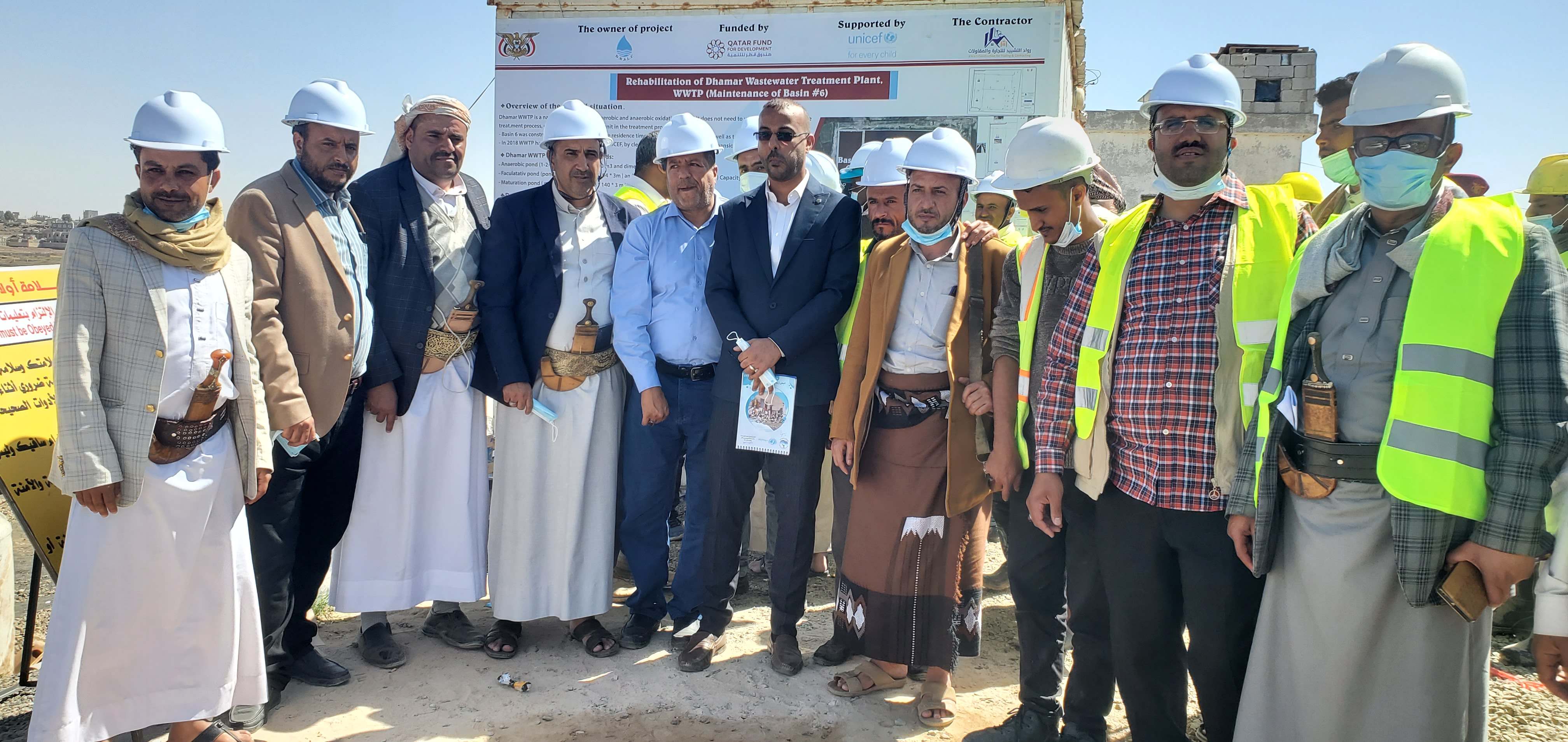 Joint UNICEF, donor delegation, and company officials in front of the project board